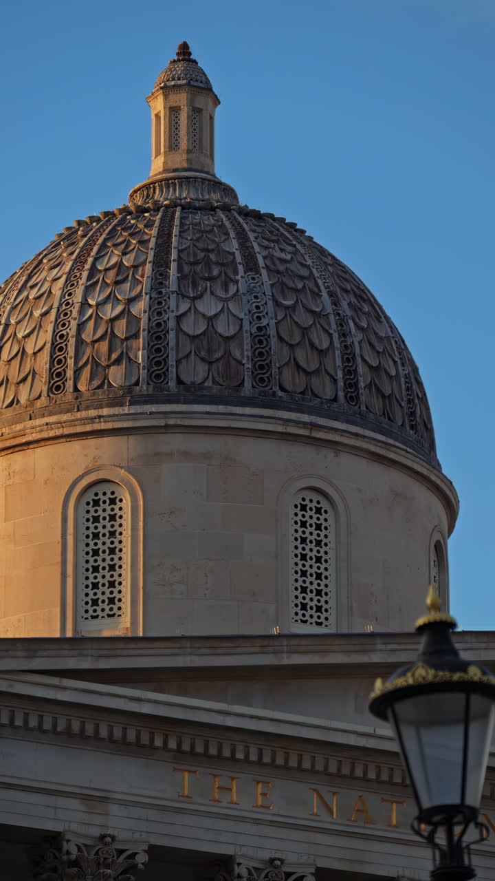 Close up of the top of The National Gallery building over blue sky. Vertical