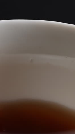 close-up of a white tea cup with brown tea inside