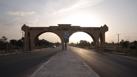 Archway-over-the-highway-welcoming-travelers-to-Jalingo,-Nigera-Taraba-State---ascending-aerial