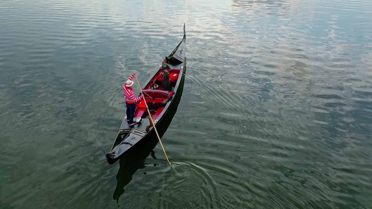 Walk on gondola in city. Gondola going down on river carrying people on board