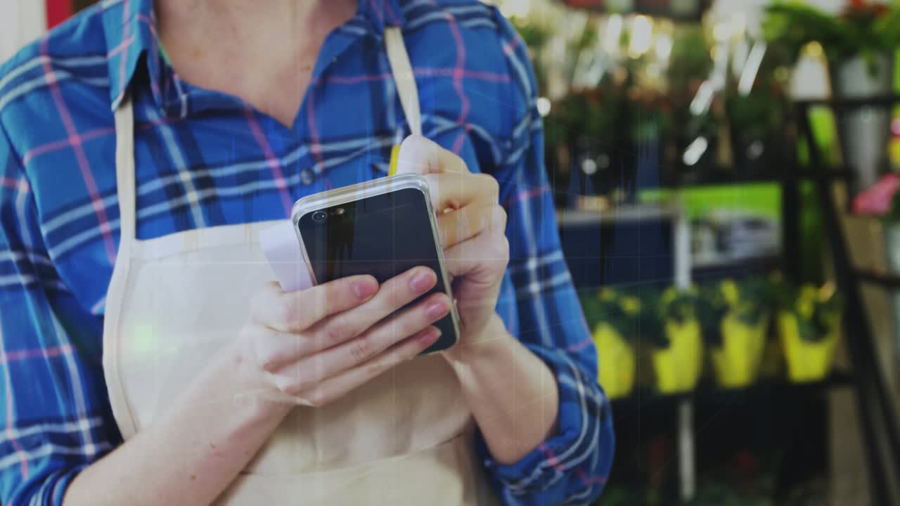 Nursery worker tapping phone, holding pencil, notepad, updating stock, causing animated icons