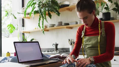 Caucasian-non-binary-transgender-woman-working-at-home,-sewing