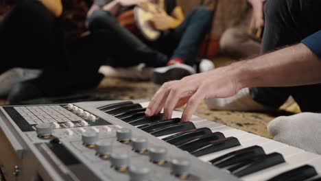 music production at home. male hands playing synthesizer, unrecognizable musicians enjoying rehearsal, tracking shot