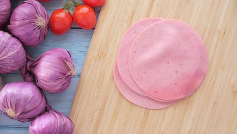 sliced mortadella on a wooden board