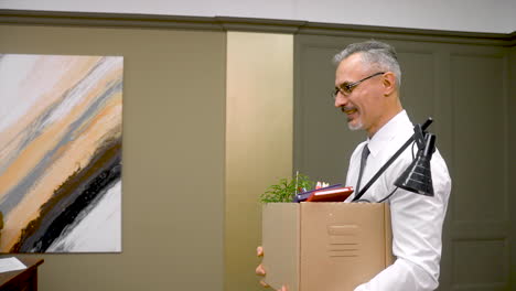 happy employee with leaving the office with his personal stuff in a box