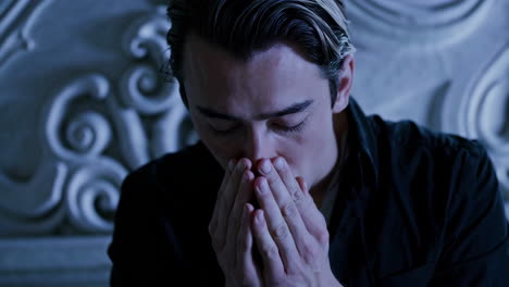 a fountain in a garden at night and a sad man