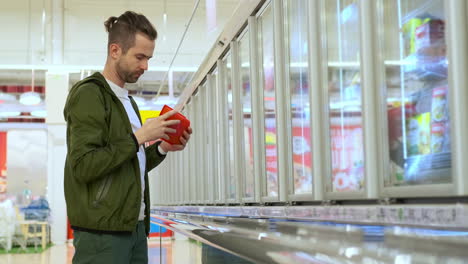 man shopping for frozen food at supermarket