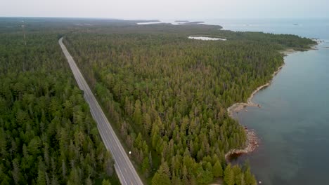 Aerial-view-of-lone-road-along-lake-coastline,-Michigan