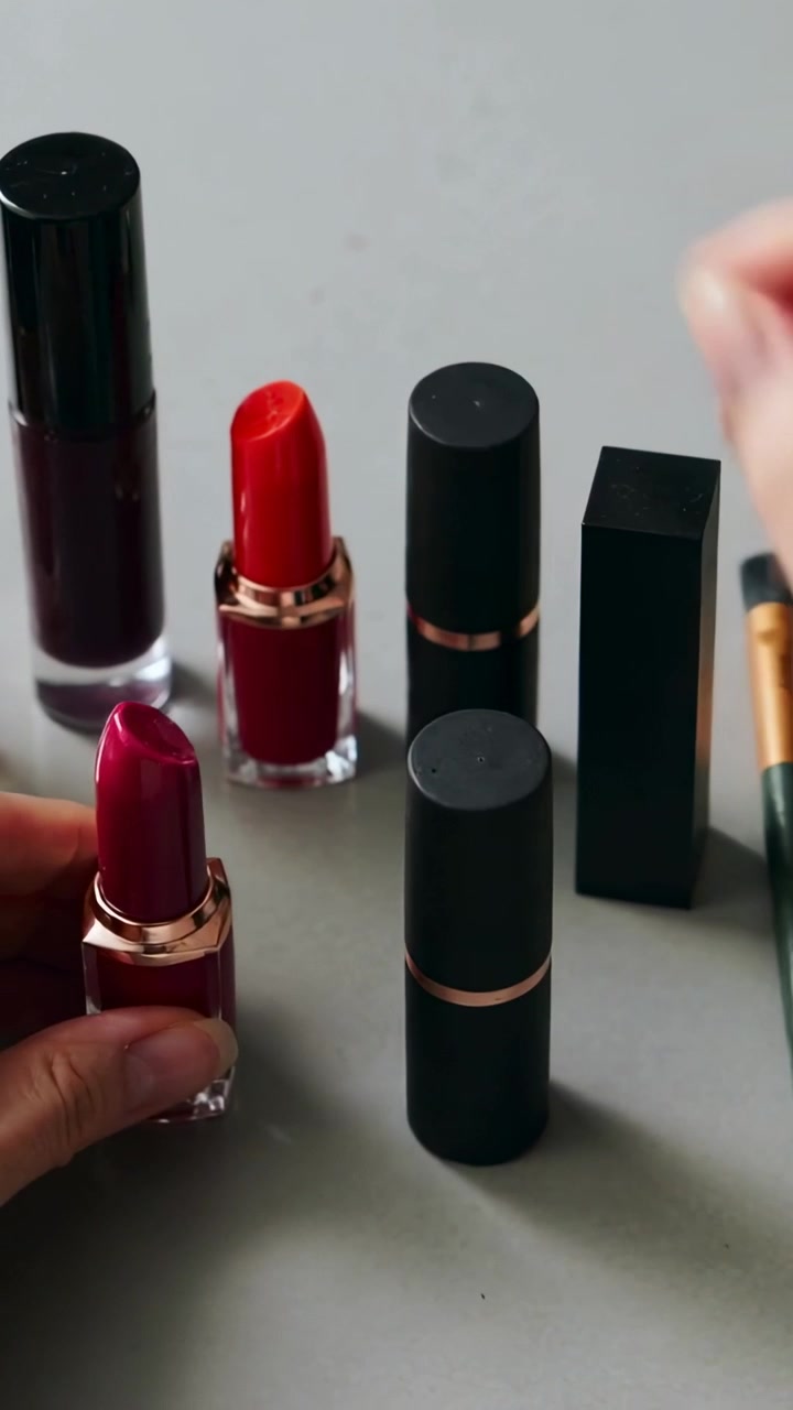 Vertical video: Entering right hand moving tubes on grey desk, lining magenta and red for display