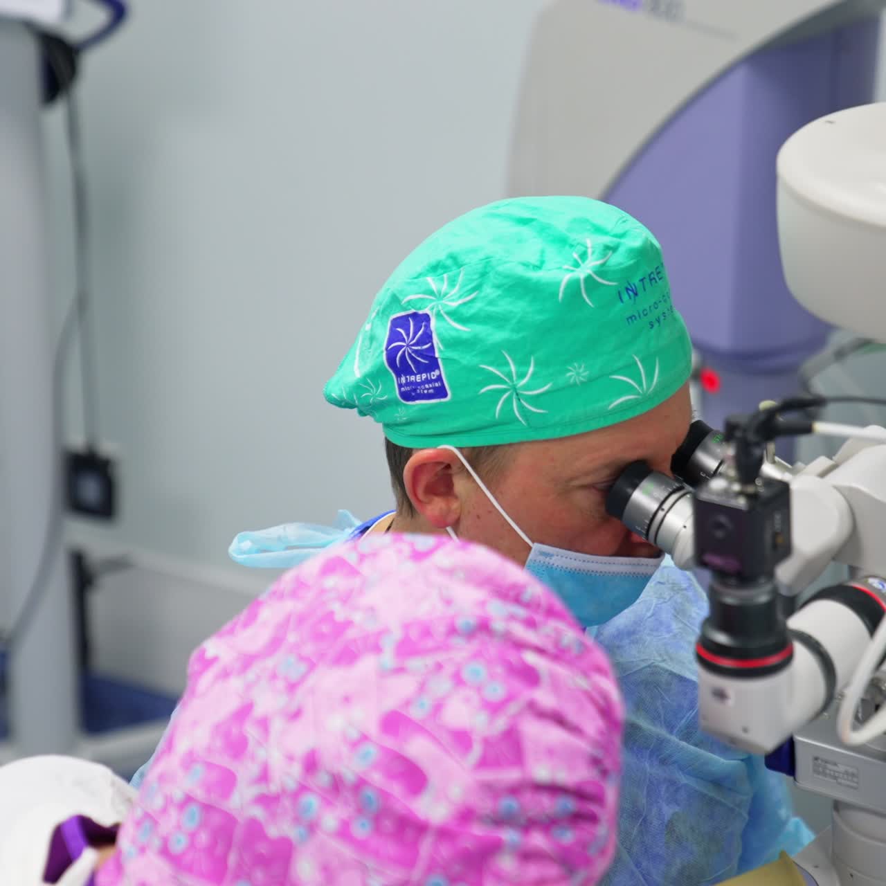 Un chirurgo oftalmico guarda attentamente dentro un binocolo. Vista dall'alto del medico che utilizza apparecchiature ad alta tecnologia per la chirurgia della vista