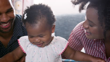 parents singing and dancing with baby daughter at home