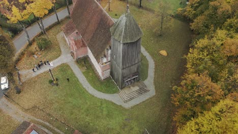 drone view of an old, historic church with a wooden tower, late autumn colors in the countryside