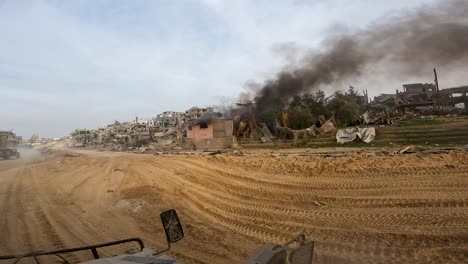 burning smoking building in destroyed gaza strip, driving pov