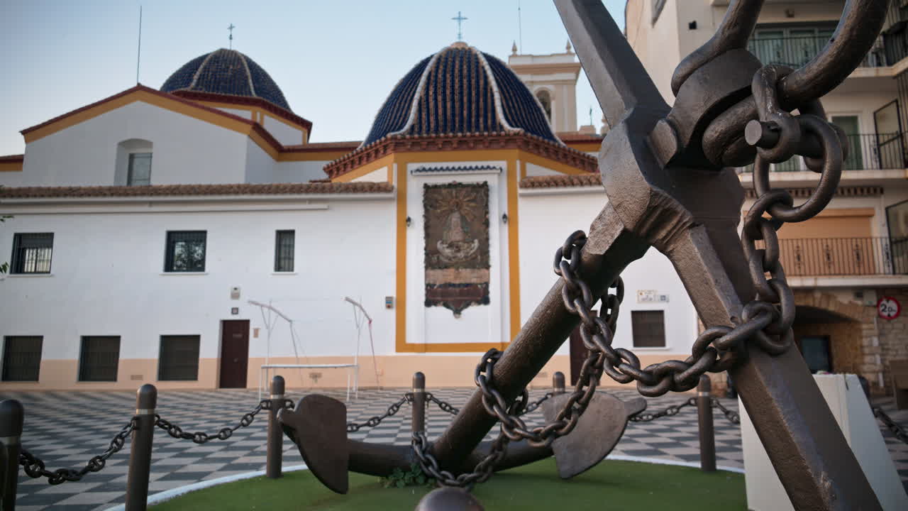 Anchor monument beside the blue domes of Iglesia de San Jaime y Santa Ana, Benidorm Old Town