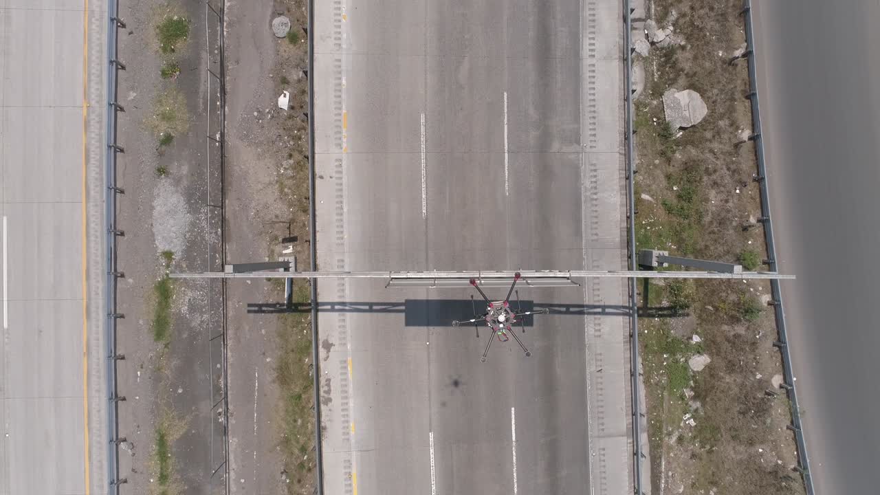 disparo de arriba hacia abajo volando por encima de un gran drone industrial sobrevolando una autopista