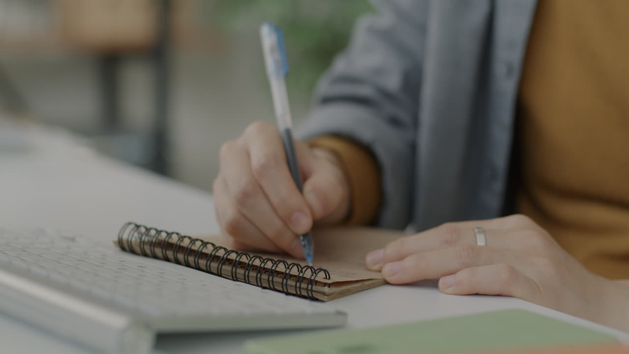 Person Taking Notes at Desk
