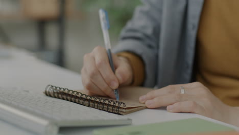 persona que toma notas en el escritorio