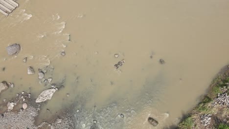 Aerial-view-of-a-man-with-floating-tub-crossing-the-river-flow