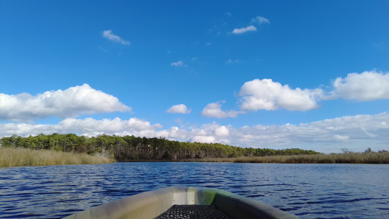 fotografía de un kayak en un arroyo de pantano salado con cielos azules