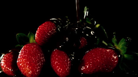 melted chocolate pouring over strawberries