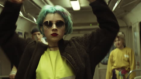 young dancers performing vogue in subway train