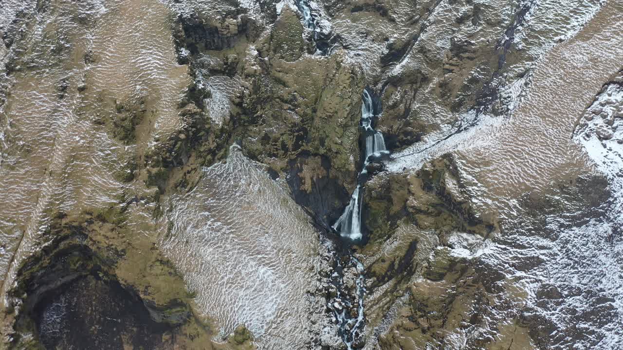 una vista aérea muestra una cascada y el paisaje que la rodea durante el invierno en islandia