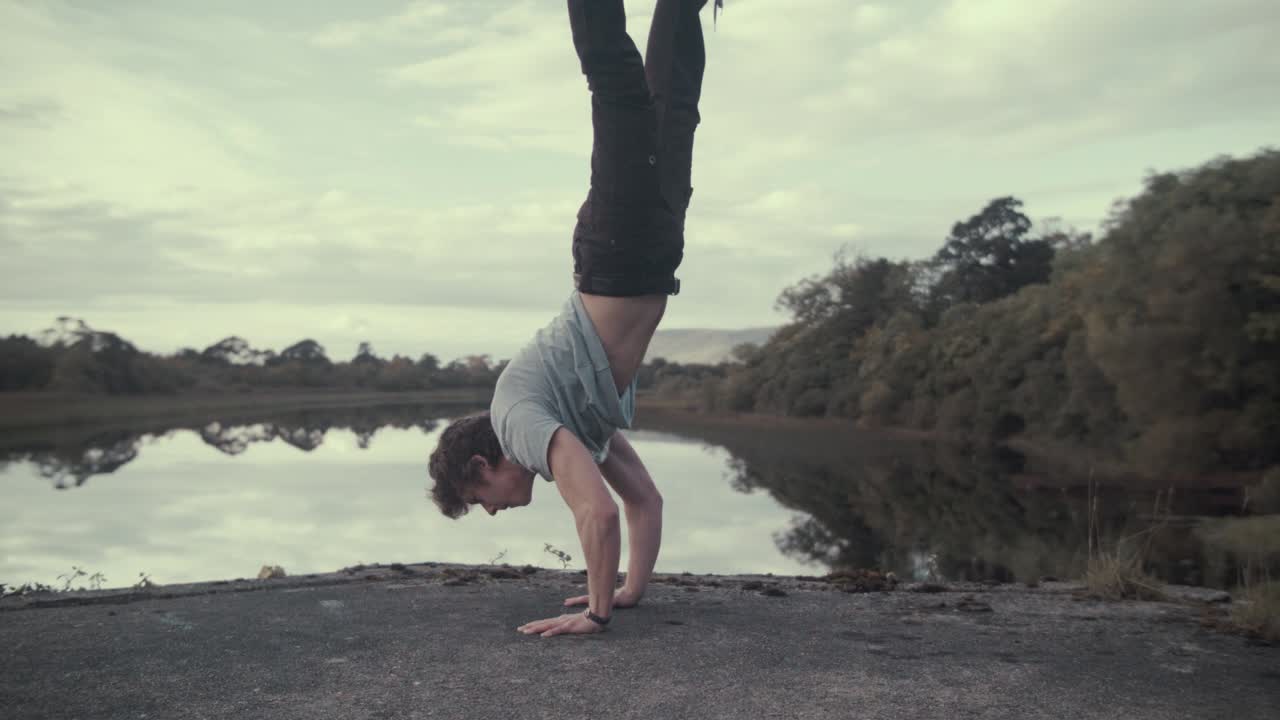 hombre atlético realiza ejercicio de fuerza de parada de manos vista impresionante