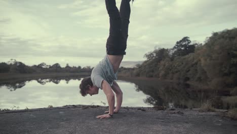 athletic man performs handstand strength exercise breathtaking view