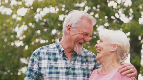 retrato de una pareja de ancianos jubilados que se abrazan al aire libre en el campo o en el jardín juntos