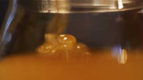 pouring honey into jar in family apiary