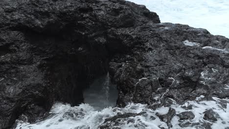 la corriente del agua de mar fluye hacia el acantilado negro