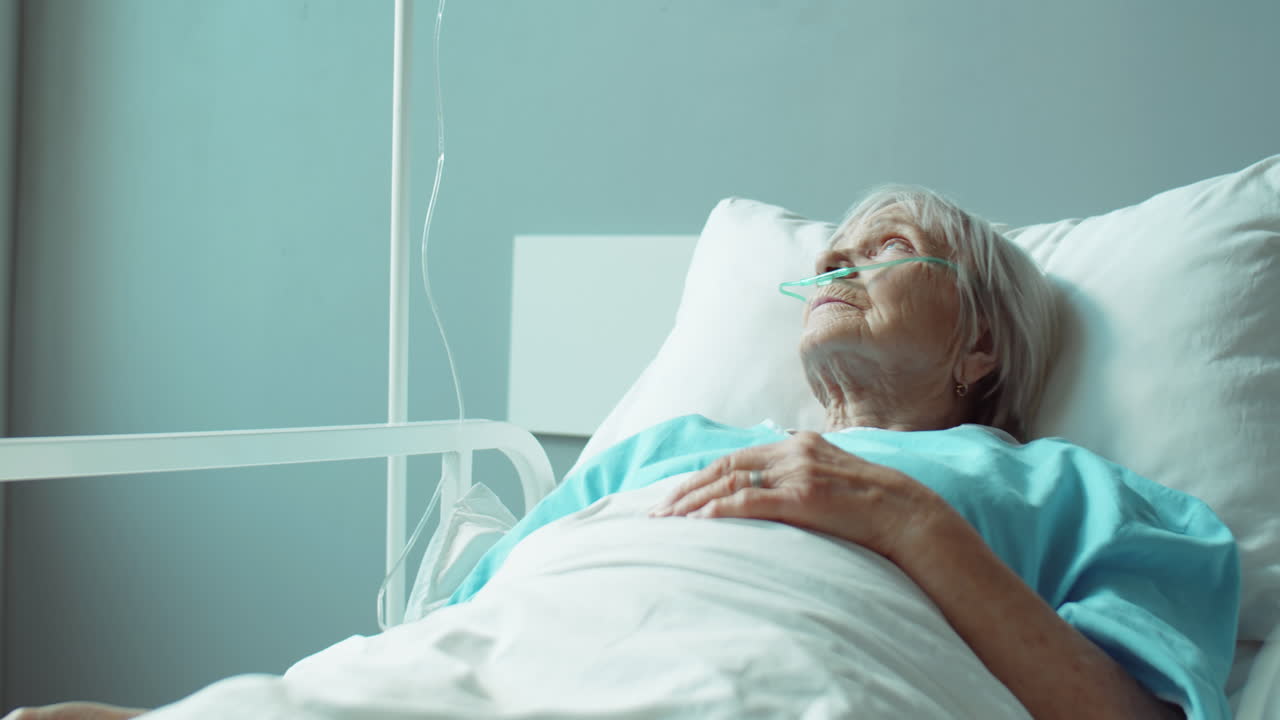 mujer anciana acostada en la cama en la sala del hospital