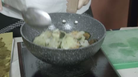 verduras de calabacín, cebolla salteada en la olla el chef mueve el plato vegetariano de primer plano