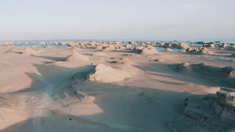 Rock-formations-in-Qinghai-Province-desert,-aerial-truck-left