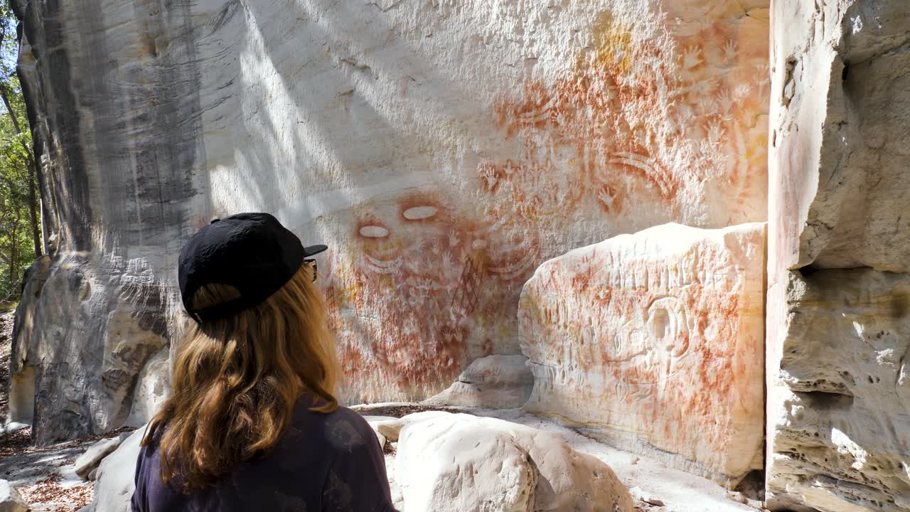 las mujeres observan la antigua tradición del arte rupestre pinturas rupestres creando historias de ensueño de los indígenas australianos