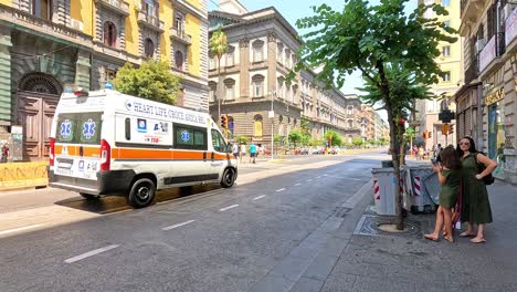 ambulance driving through a busy naples street