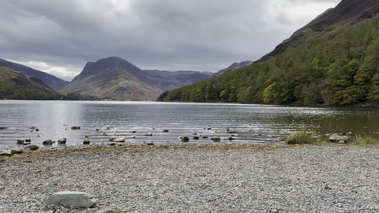 Peaceful shoreside view of Lake Buttermere with gentle ripples in water - Lake District