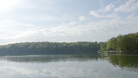 Man-standing-on-moving-motorboat-in-lake-on-sunny-day