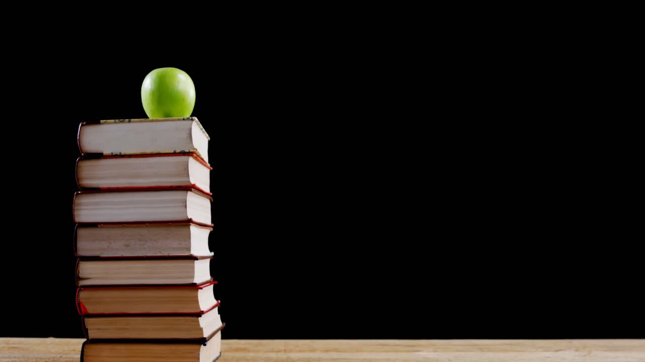 Green apple on book stack