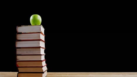 manzana verde en la pila de libros