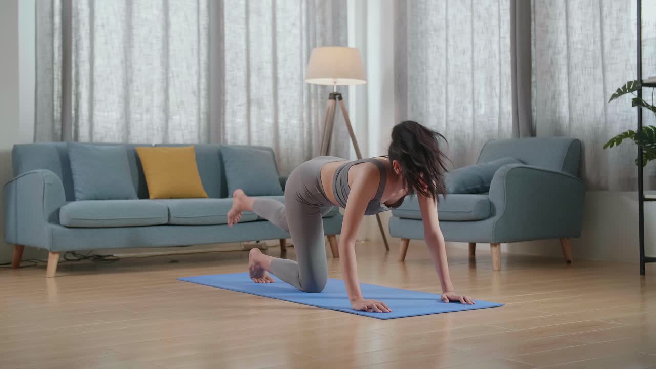 joven atleta asiática haciendo ejercicio, estirándose y practicando yoga en casa. estilo de vida saludable, fitness, bienestar y concepto de atención plena