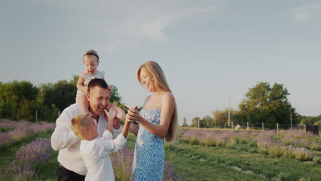 Portrait-of-a-happy-family-in-a-lavender-field,-their-house-in-the-distance