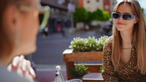 dos mujeres charlando en un café al aire libre