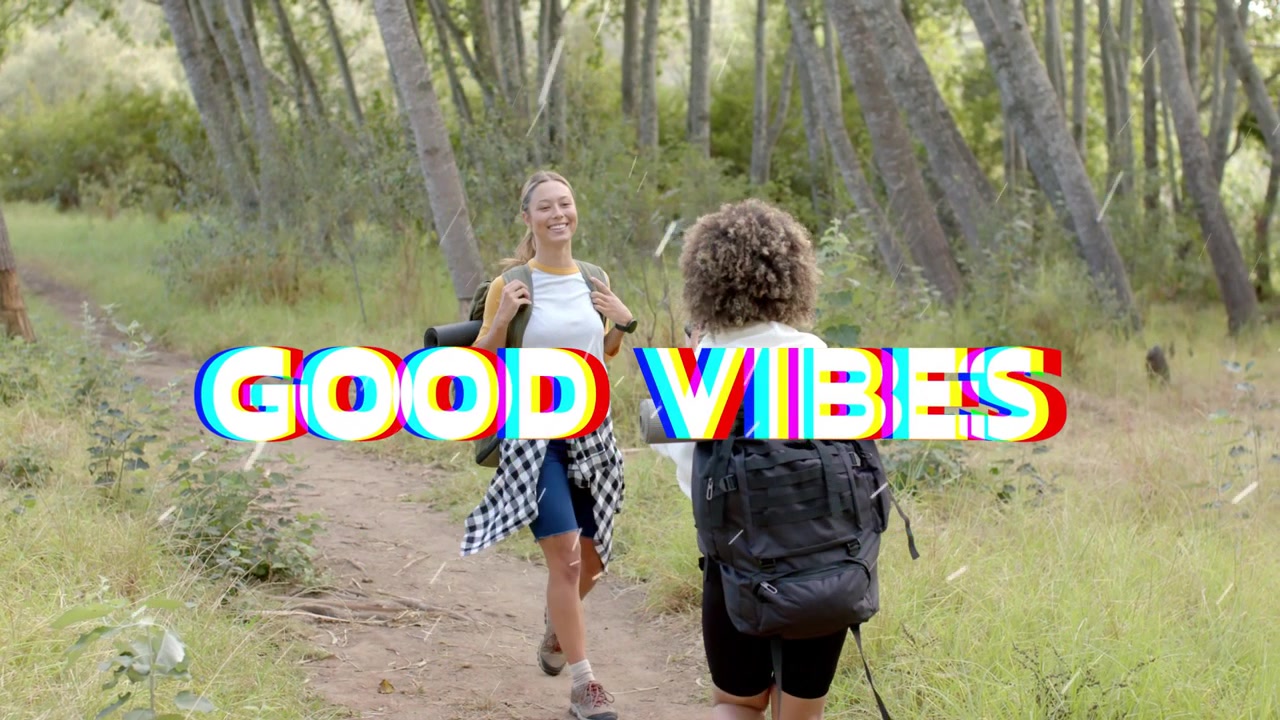To turgåere møter stien, med "GOOD VIBES" som glitsjer over dem, en turgåer løfter telefonen og tar en reiseselfie.