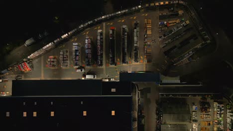 storage yard under building lights gleam, pallets and crates in shadow dream