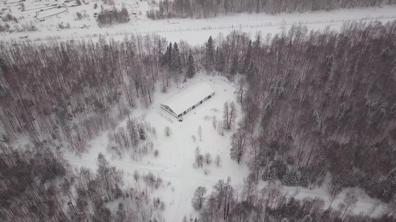 снежный лес с заброшенным зданием - вид с воздуха