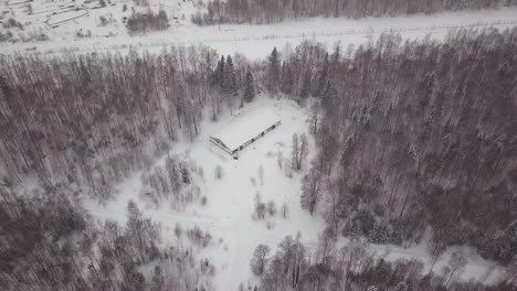 snowy forest with abandoned building - aerial view