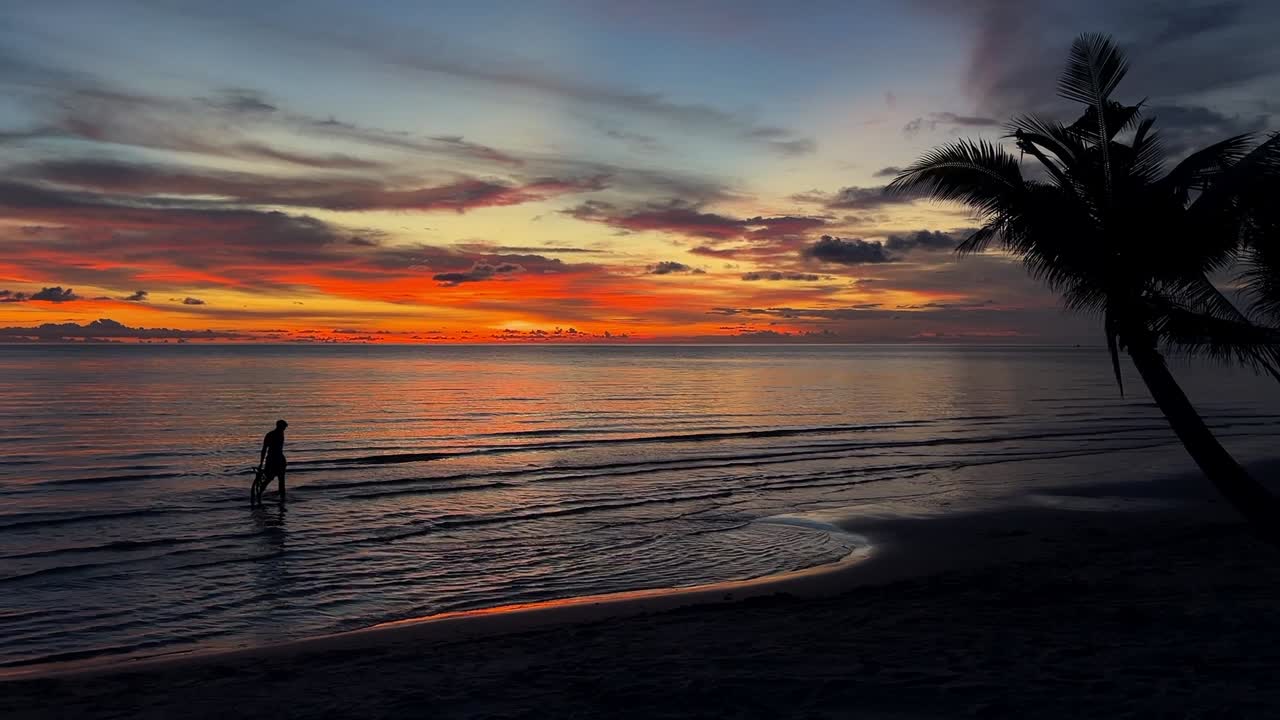 siluetas de personas al atardecer en una playa tropical