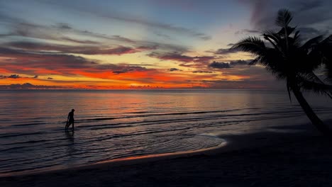 silhouettes of people at sunset on tropical beach