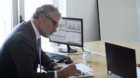 focused busy male trader working with the computer